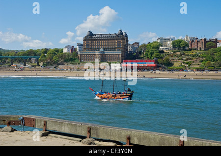 Tourists enjoying a trip on the Hispaniola, Scarborough's scaled down pirate ship, with the Grand Hotel at South Bay in the back Stock Photo