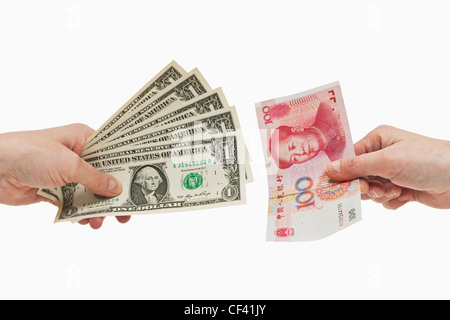 Five 1 U.S. Dollar bills are held in the hand. At the other side a 100 yuan bill is held in the hand, background white. Stock Photo