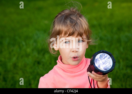 girl playing with lantern. Portrait of girl against a grass. grass background Stock Photo