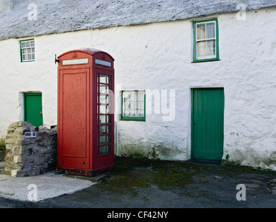 A public telephone box outside a remote farmhouse, previously a sub post office in Maenaddwyn. Stock Photo