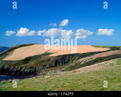 A line of clouds above the rolling contours of the Pembrokeshire coastline. Stock Photo