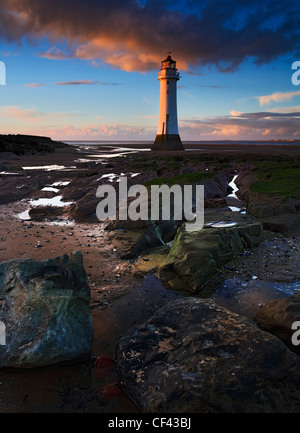 Sunset over New Brighton Lighthouse (Perch Rock Lighthouse). The lighthouse was built in 1827 although ceased to be used as a li Stock Photo