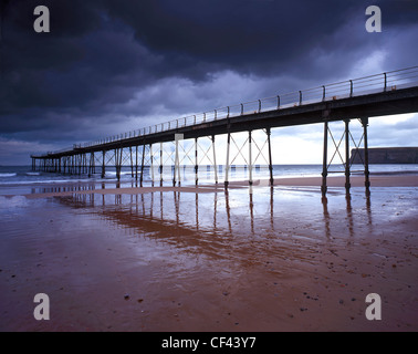 Saltburn Pier, the last pier remaining in Yorkshire, at low tide as storm clouds gather overhead. Stock Photo