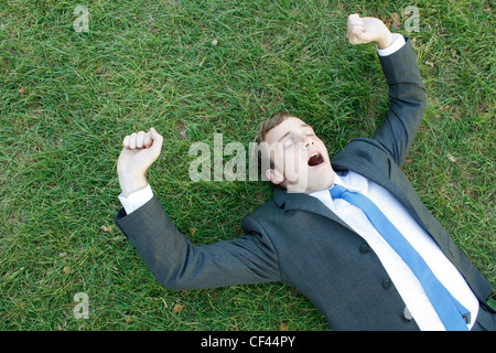 A business man lying on the grass Stock Photo