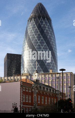 The Gherkin at 30 St Mary Axe in the City of London seen behind older buildings including the Sir John Cass foundation in Jewry Stock Photo