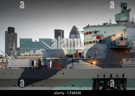 A view of HMS Belfast with the City of London skyline behind. Stock Photo