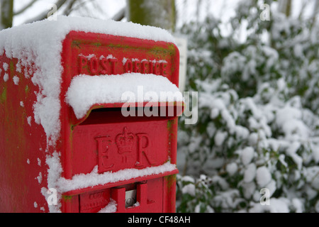 Snow covers a traditional British rural post box in Essex. Stock Photo