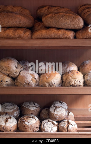 Loaves of bread displayed on a shelf in a bakery shop Stock Photo - Alamy