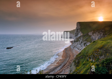 Sunset from above Durdle Door looking towards Bat's Hole along the Jurassic coast with the Bull rock on left. Stock Photo