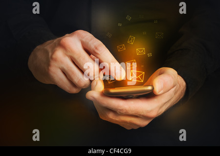 Man in black shirt is typing a text message on his smartphone, close up image, focus on hands and the phone device. Stock Photo