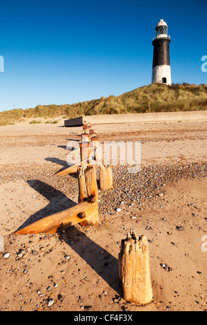 Spurn Point, or Spurn Head, lighthouse, with worn sea defence posts. Stock Photo