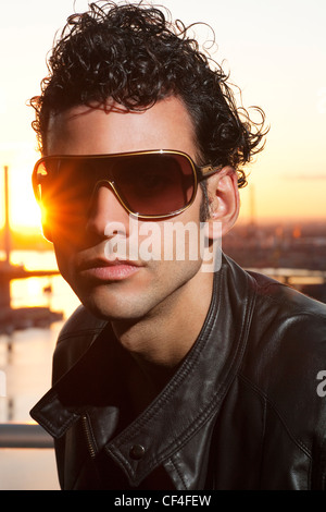 Man in mid twenties wearing glasses during sunset. Stock Photo