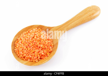 Red lentils in wooden spoon on white background Stock Photo