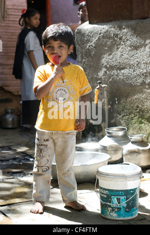 Boy with ice popsicle posing for the camera - Annawadi, Mumbai Stock Photo