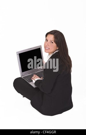 Businesswoman sitting with a laptop in her lap and looking up back over the shoulder. Stock Photo
