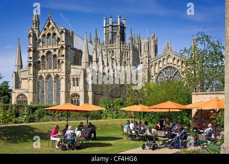 Visitors to the Almonry Tea Rooms and Restaurant enjoying breakfast in the summer sunshine in front of Ely Cathedral.