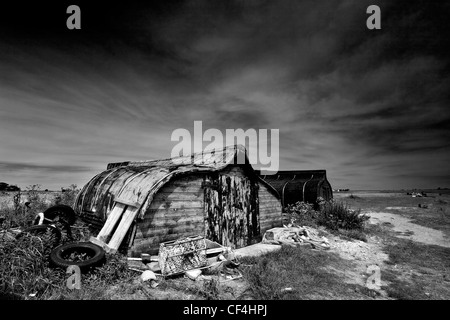 Old herring boats cut in half and turned upside down to be used as huts. Stock Photo