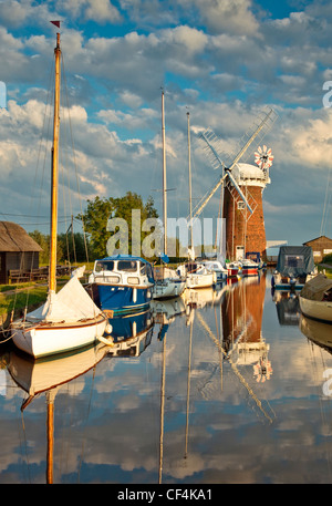 Relections of Horsey Windpump and boats in Horsey Mere on the Norfolk Broads. Stock Photo