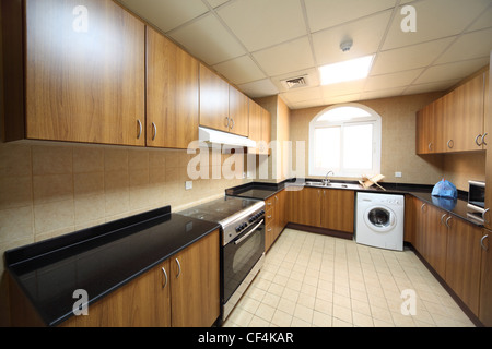 kitchen with brown cupboards, washingmachine and cooker Stock Photo