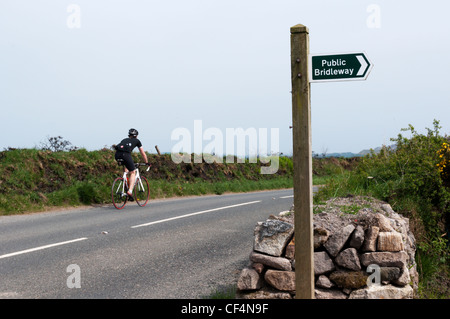 A cyclist passing a Public Bridleway sign in North Cornwall, England. Stock Photo