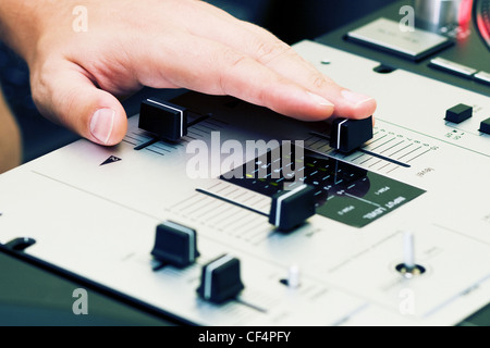 Hand of a disc jockey on the professional mixing controller Stock Photo