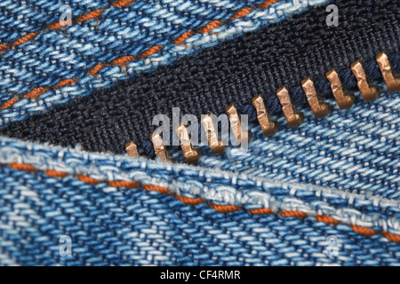 wear a piece of blue denim structure of the yellow line and zipper, macro Stock Photo