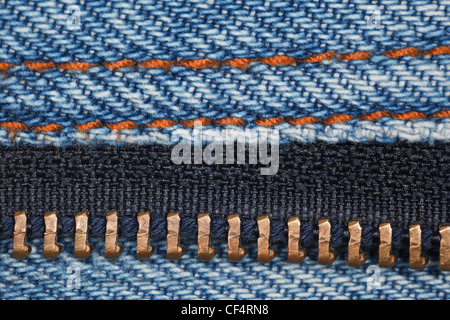 wear a piece of blue denim structure of the yellow line and zipper, macro Stock Photo