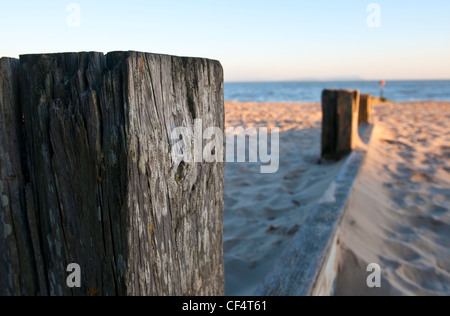 A wooden groyne running across Avon beach towards the sea to prevent longshore drift over the beach. Stock Photo