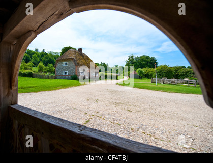 View through wooden arch to thatched early‚Äö√Ñ√¨mid 17th century house from Walderton at the Weald & Downland Open Air Museum. Stock Photo