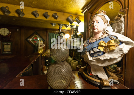 A bust of Queen Victoria and a vintage soda syphon on the bar in a reconstructed pub at Abbey House Museum. Stock Photo