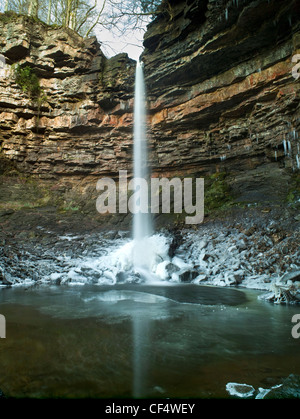 Hardraw Force, England's highest unbroken waterfall, falling onto frozen water in winter. Stock Photo