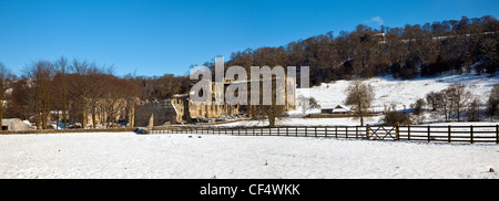 Snow covering the the ground around the ruins of Rievaulx Abbey, a former Cistercian abbey founded in 1132 and dissolved by Henr Stock Photo