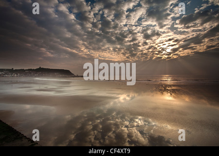 Mottled clouds reflected on the glistening beach of the South Bay at Scarborough at sunrise. Stock Photo