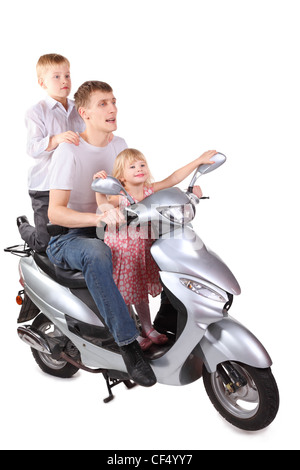 father and his son and daughter is sitting on      motorcycle. focus on father's right leg. isolated. Stock Photo