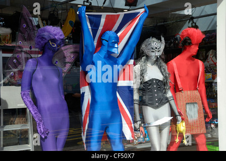 Mannequins dressed in outlandish fancy dress costumes on display in a shop window. Stock Photo