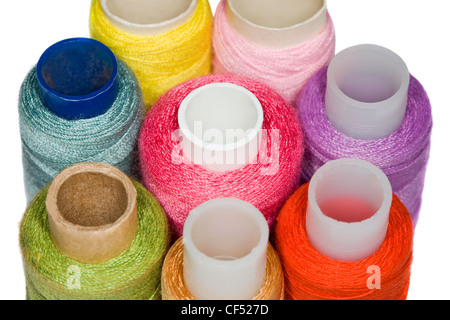 spools with multi-coloured sewing threads isolated on white background, close-up Stock Photo