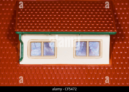 attic on roof of toy plastic house,two windows Stock Photo