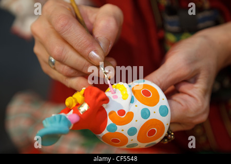 Painting pottery figurines. Russian folk craft. Close-up photos. Stock Photo