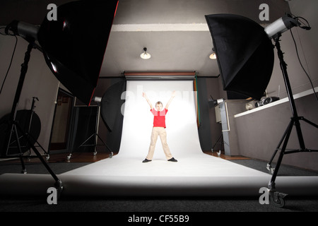 interior of professional photo studio boy in red shirt standing on white background Stock Photo