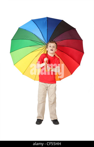 little boy in red shirt opened mouth with big multicolored umbrella standing on white Stock Photo