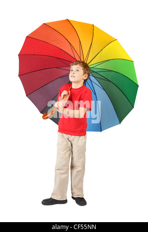 boy in red shirt with big multicolored umbrella standing on white and looking at side Stock Photo