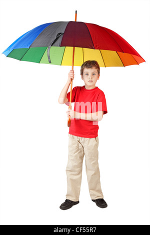 little boy in red shirt with big multicolored umbrella standing on white looking at camera Stock Photo
