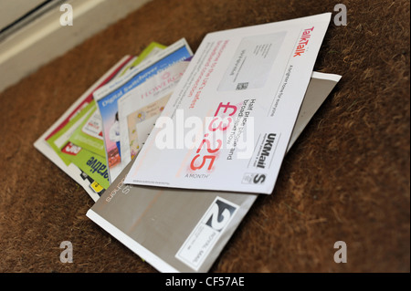 Junk mail in a private home on door mat after being delivered by postman UK Stock Photo