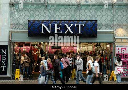Shoppers hurrying past Next fashion shop in Oxford Street. Stock Photo