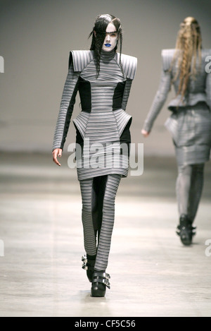 Gareth Pugh London Ready to Wear Autumn Winter Grey striped structured dress with oversize shoulderpads, matching leggings Stock Photo