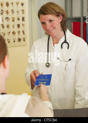 Veterinary woman with vaccination pass, smiling Stock Photo