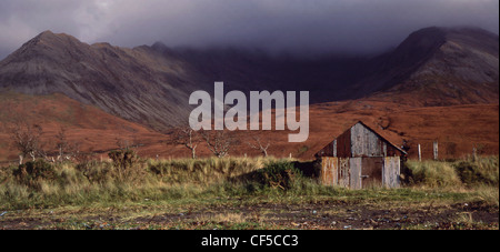 View of corrugated hut in a glen with Cuillin Mountains in the background. Stock Photo