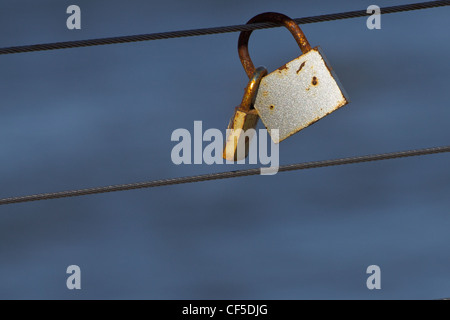 Rusty padlocks hanging on the cable in Rewal, Poland. Stock Photo