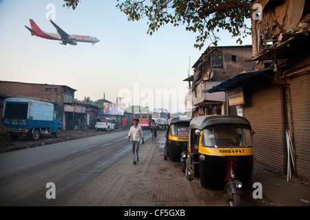 Plane landing at Mumbai International Airport next to slums Stock Photo