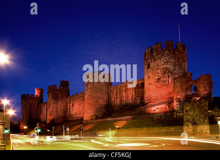 Conwy Castle lit up at dusk. The castle was an important part of King Edward I's plan of surrounding Wales in 'an iron ring of c Stock Photo